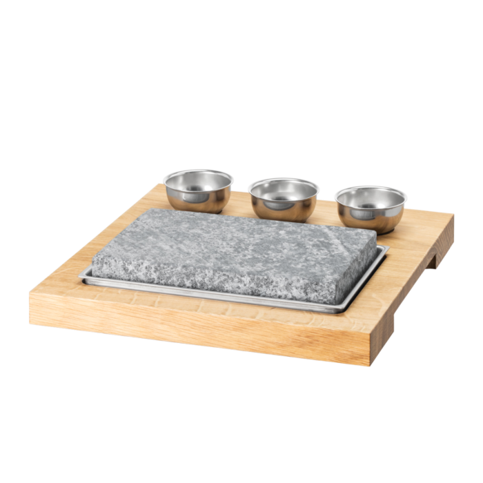Heisser Stein mit Holzbrett und Saucenschälchen